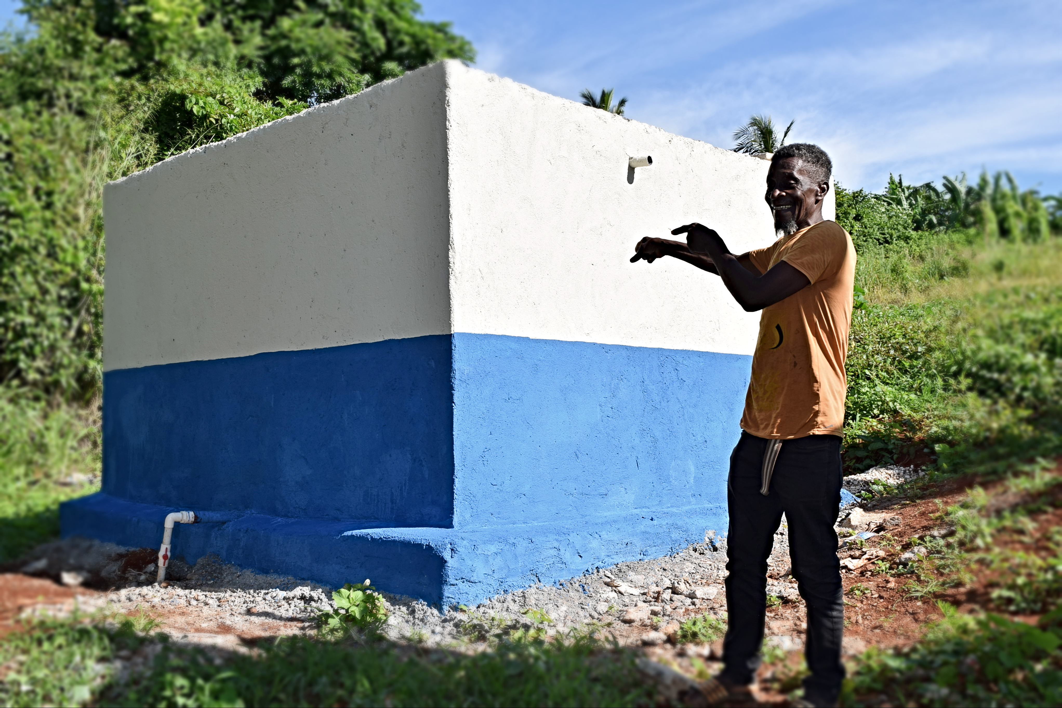 A farmer in Jamaica tests the communal water from this storage tank to make sure it's fit for use.